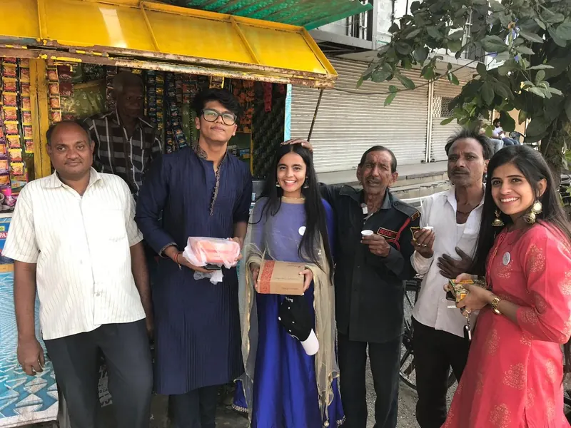 Volunteers with a security guard and shopkeepers outside a small paan shop